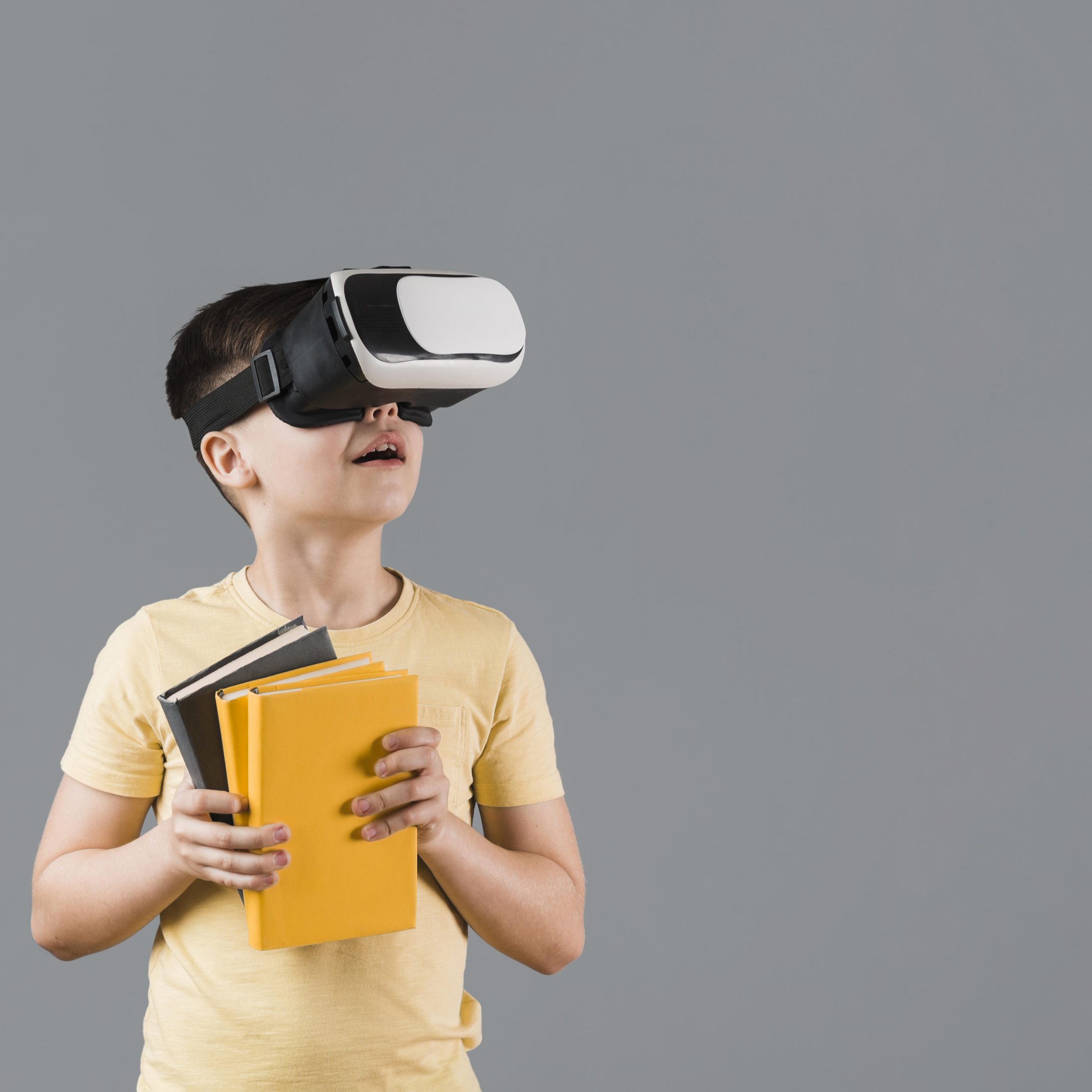 Menino segurando livros e utilizando óculos VR